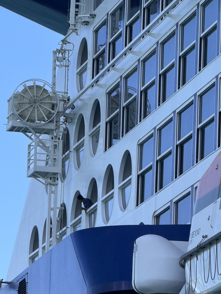 Exterior of Celebrity Beyond showing the porthole balconies and window-washing equipment mounted beside them